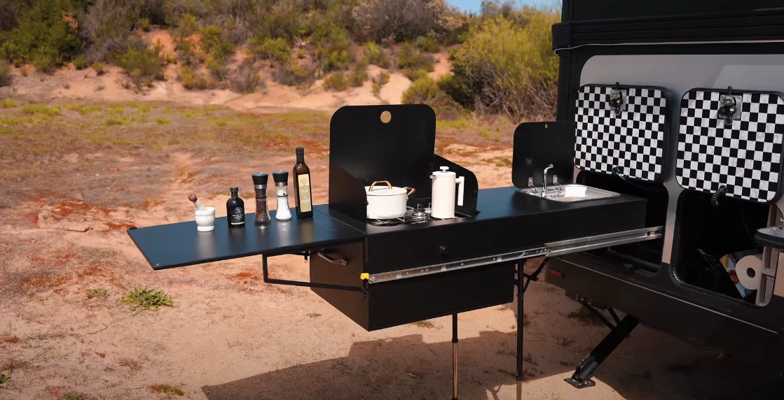 The outdoor kitchen includes a triple-burner stove, sink and plenty of work space