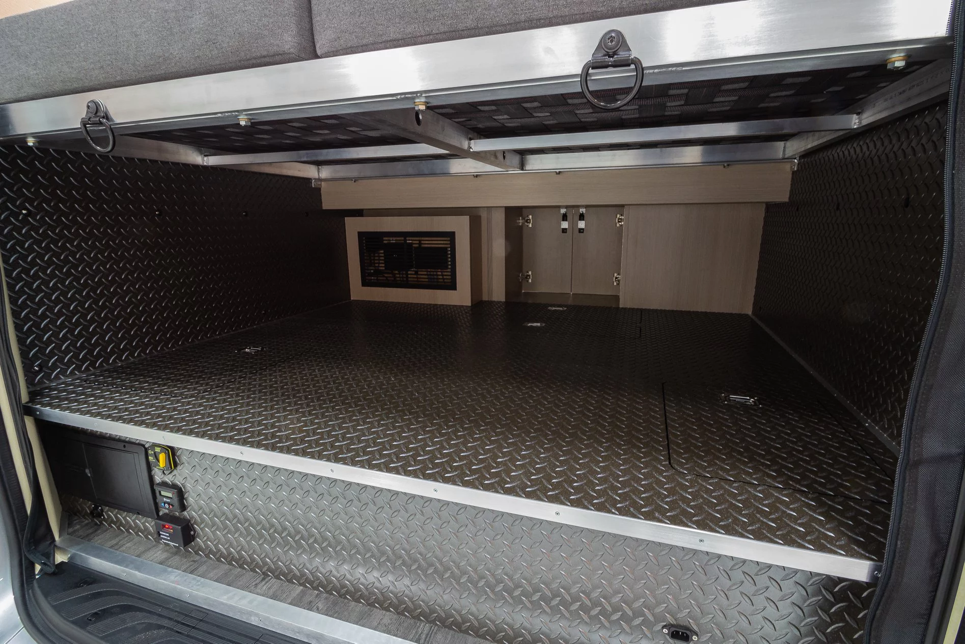 This sort of false-floor garage below the bed houses the batteries and key electrical and computer components