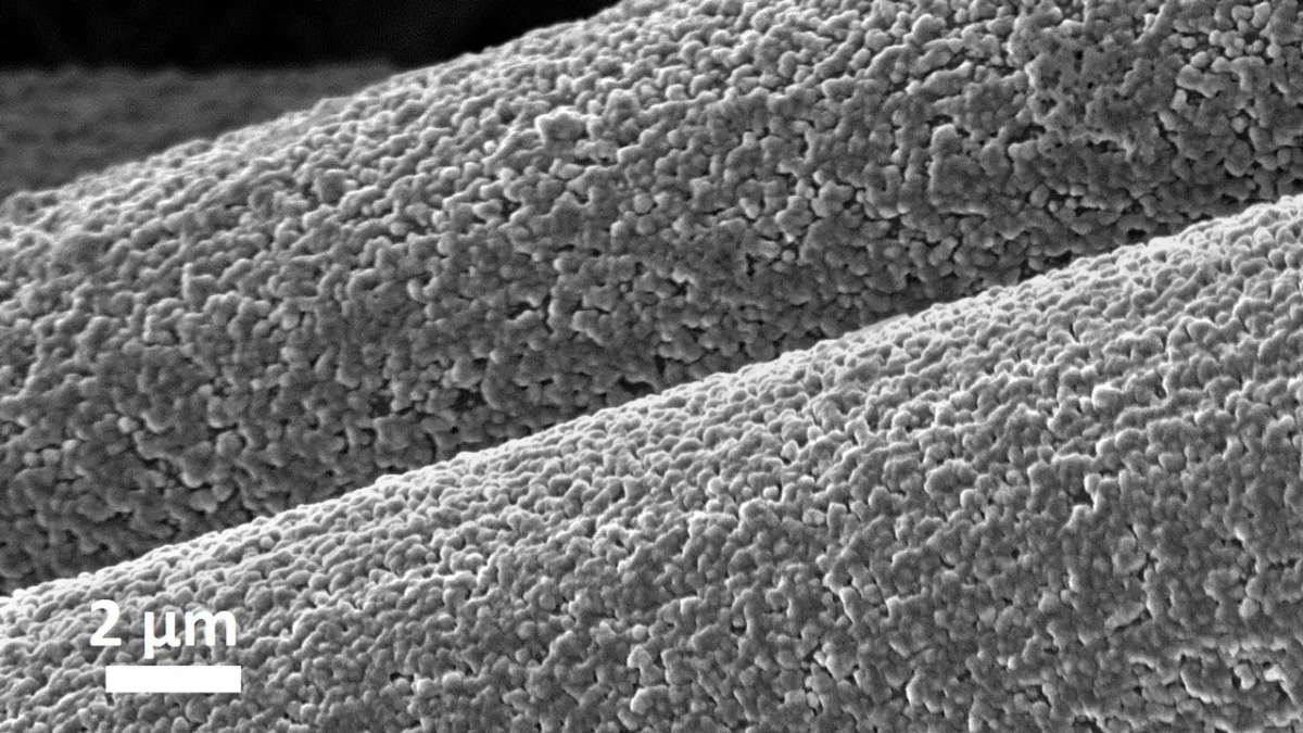 A magnified image showing aluminum depositing on carbon fibers as part of a low-cost battery electrode