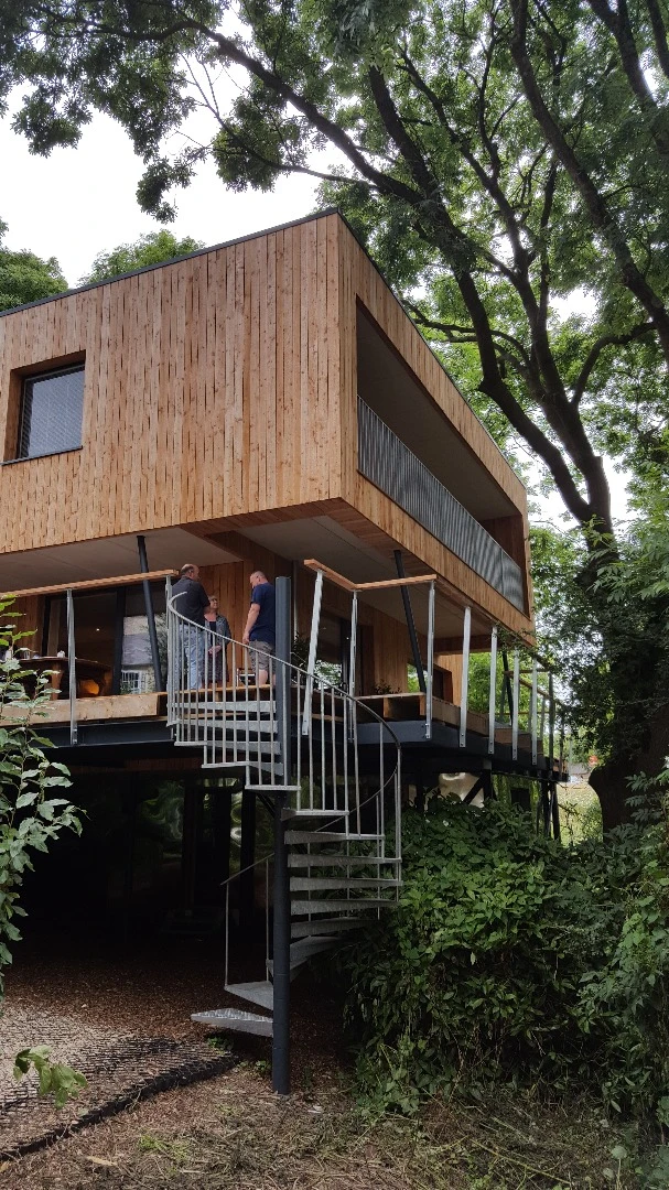 Sitting some 12 m (39 ft) above the ground, the stunning treehouse-inspired home stretches over three levels