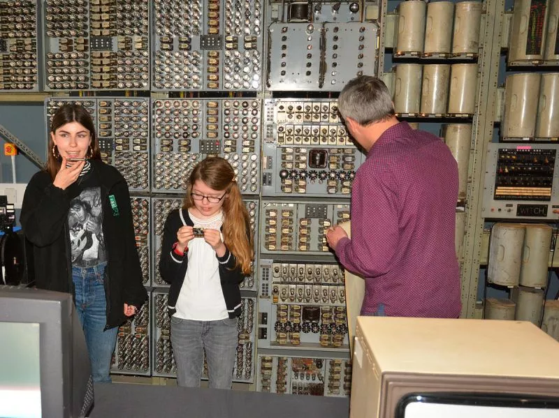 To the left, an iPhone 6s. In the middle, 9 year-old Connie with a BBC micro:bit computer. And along the back wall, a 1951 Harwell Dekatron/WITCH
