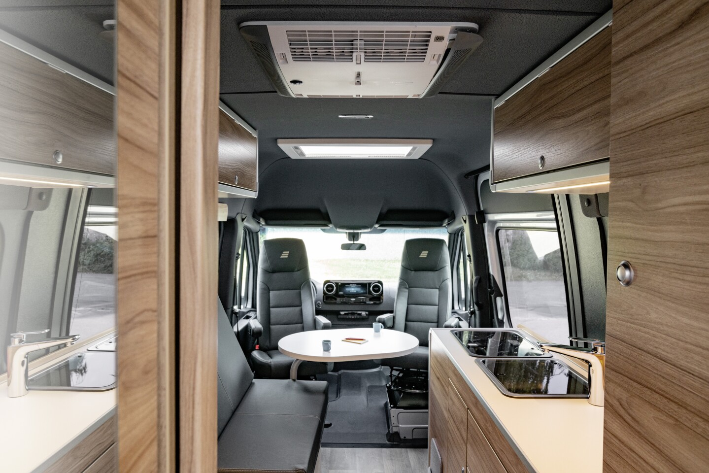 Though there's a side-facing sofa/dining bench, the driver cab seats still swivel, and from the looks of it, the table might be able to swivel over to turn those seats into a small dining area for two