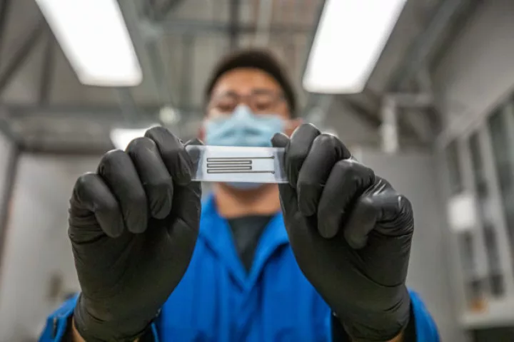 Researcher Junpyo Kwon holds a sample of the team's biodegradable electronic circuit