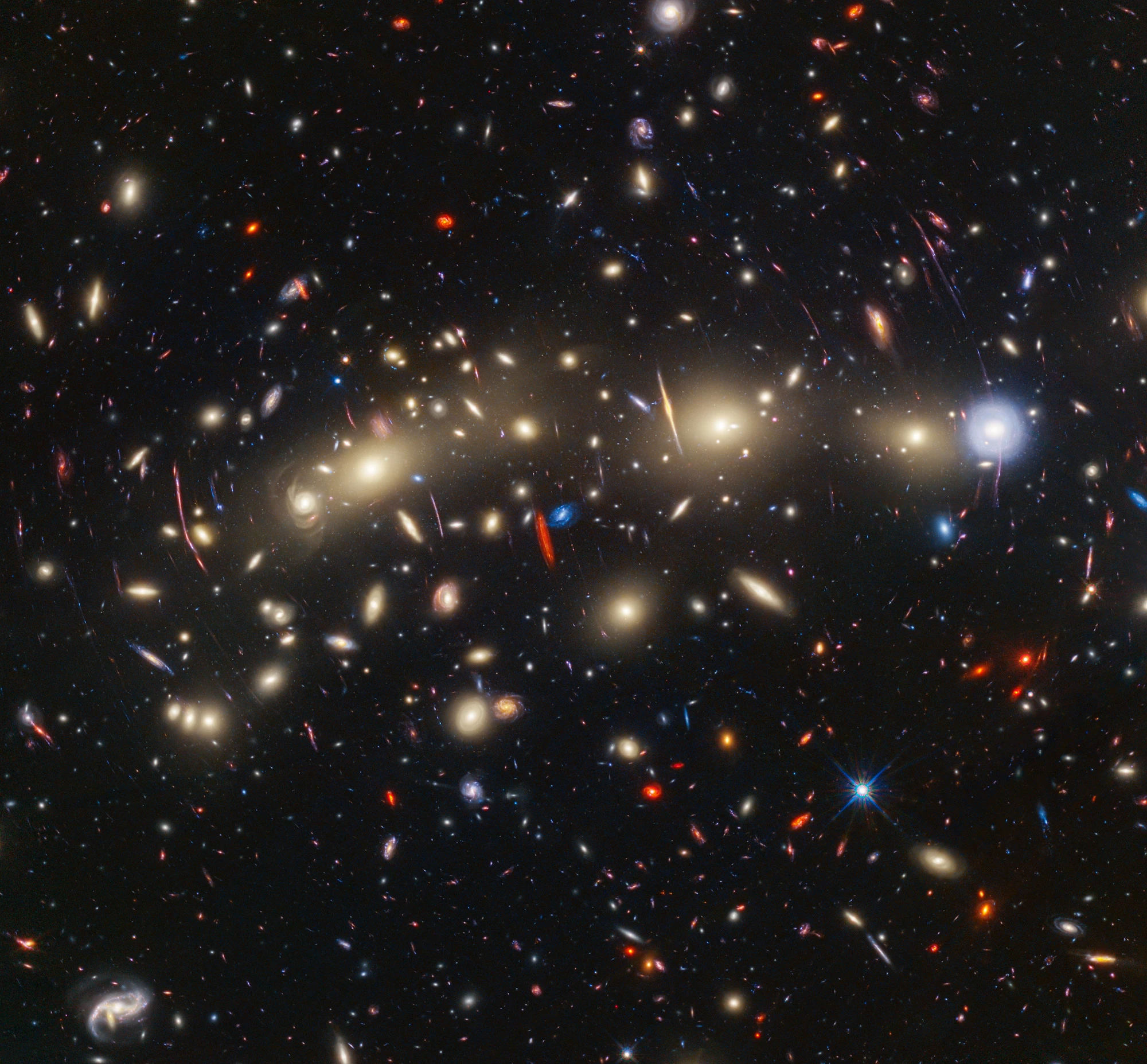 A composite image of the "Christmas Tree Galaxy Cluster" or MACS0416, created by stacking Hubble and James Webb images