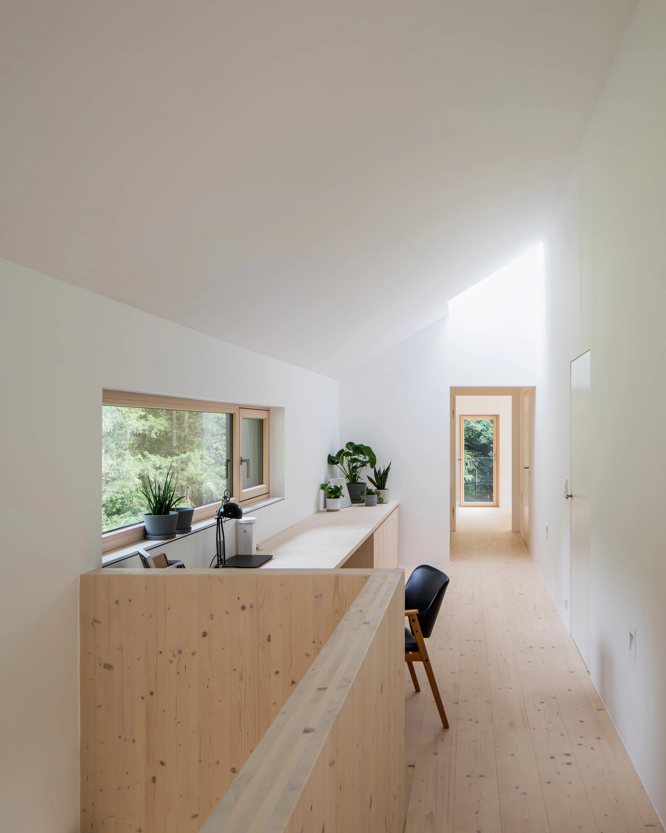 The Mountain House occupies a sloping plot of land in Upper Austria, with thick forest to one side and expansive valley views on the other