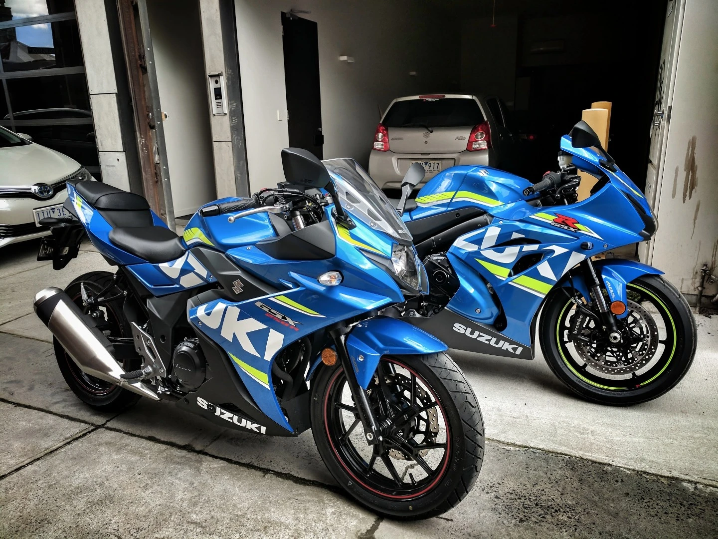 Family photo: The GSX-250R (front) beside the GSX-R1000 superbike. With a Suzuki Alto behind it in the New Atlas garage. A very Suzi day!
