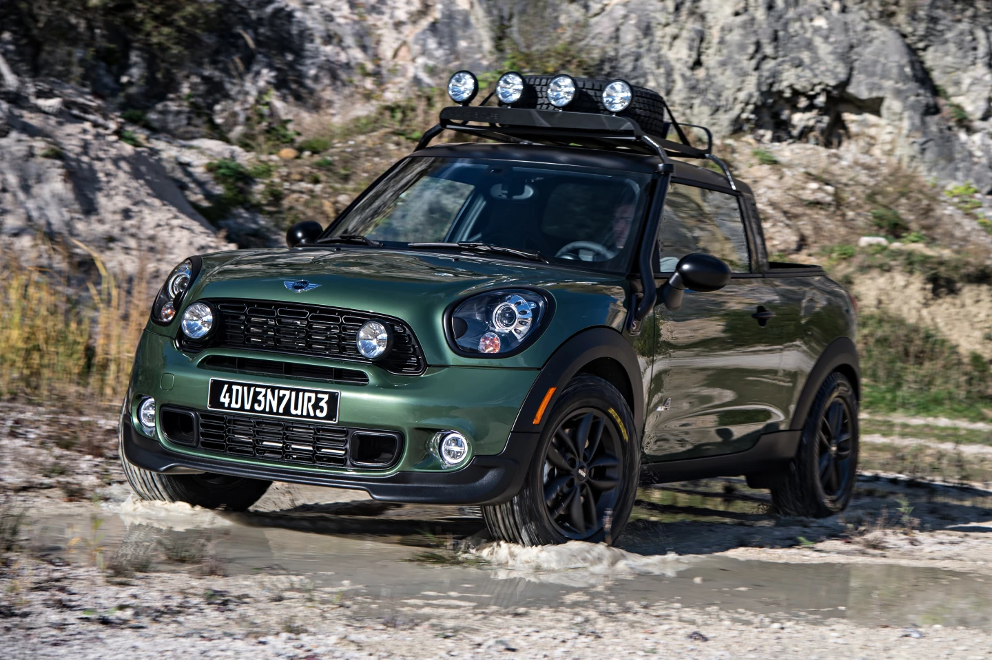 The roof rack holds a spare tire and includes lights for night off-roading