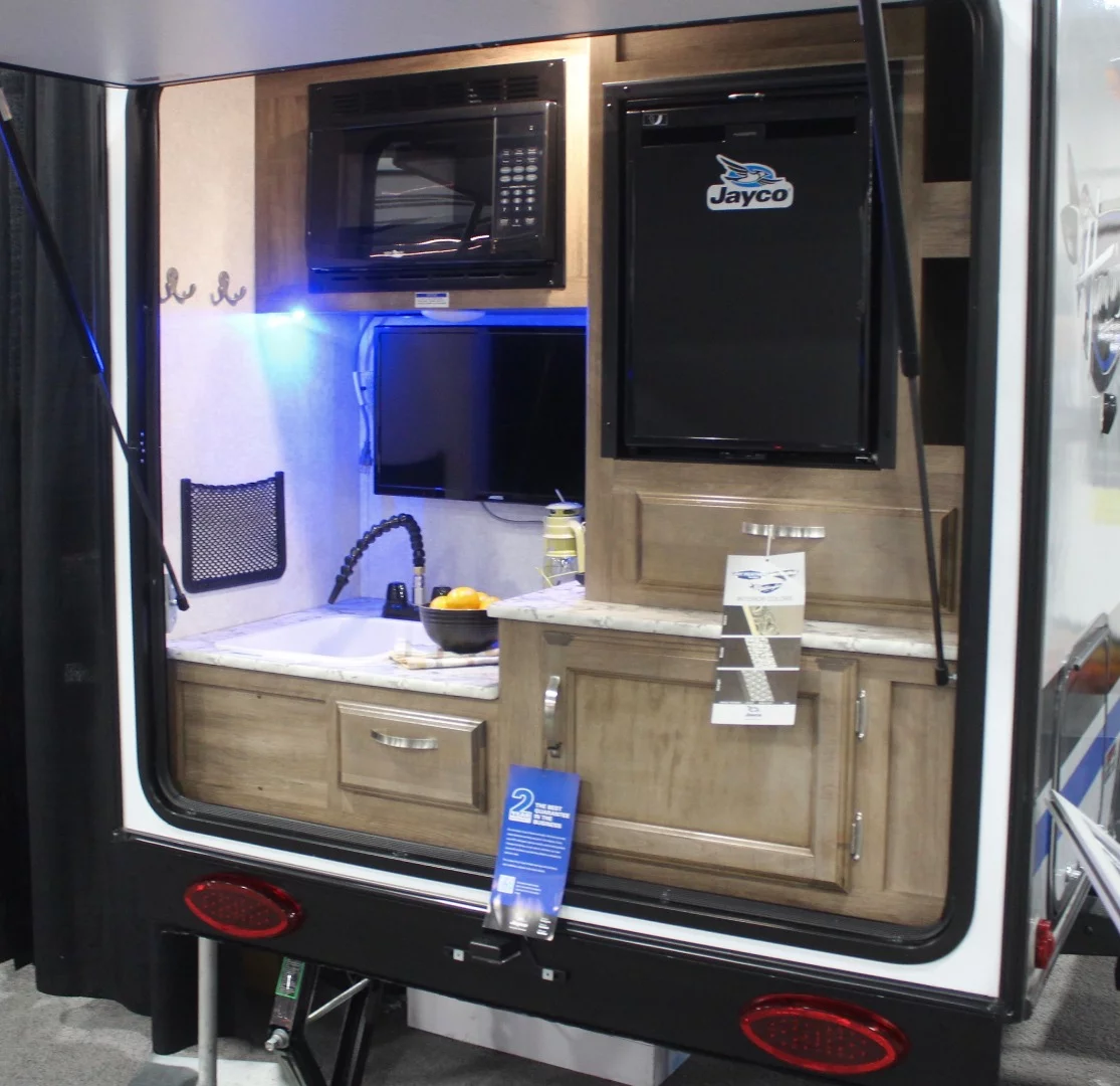 Call us crazy, but we'd prefer a larger refrigerator (or extra space for a cooler) and/or added cabinets over a microwave and outdoor TV