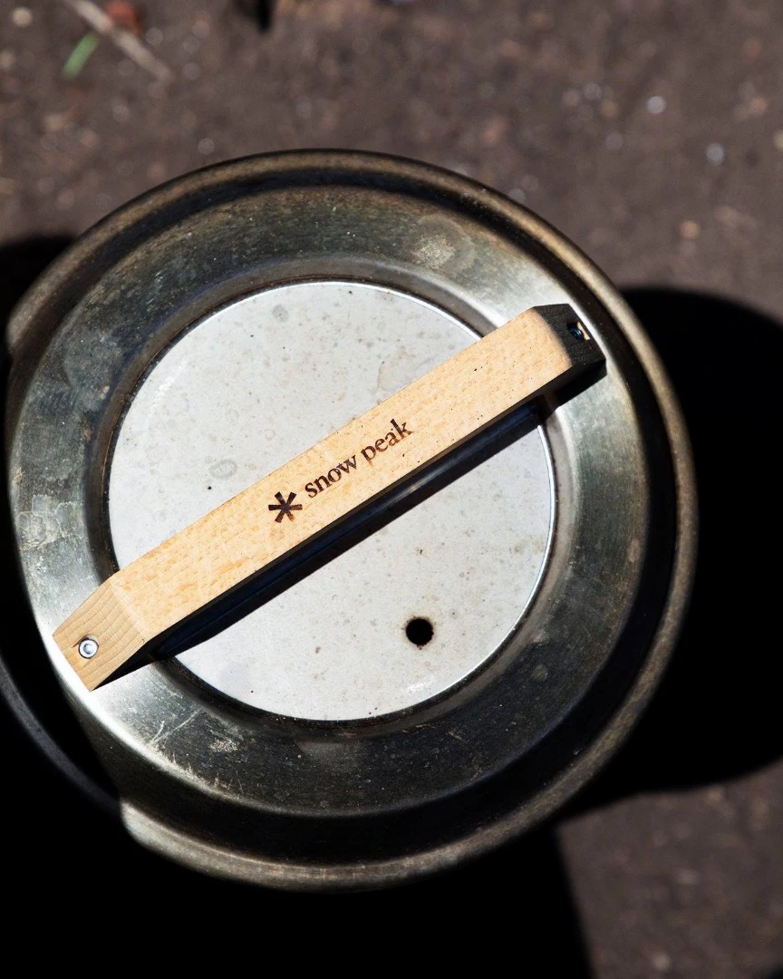 The Smokemeister bbq is topped by a wooden handle