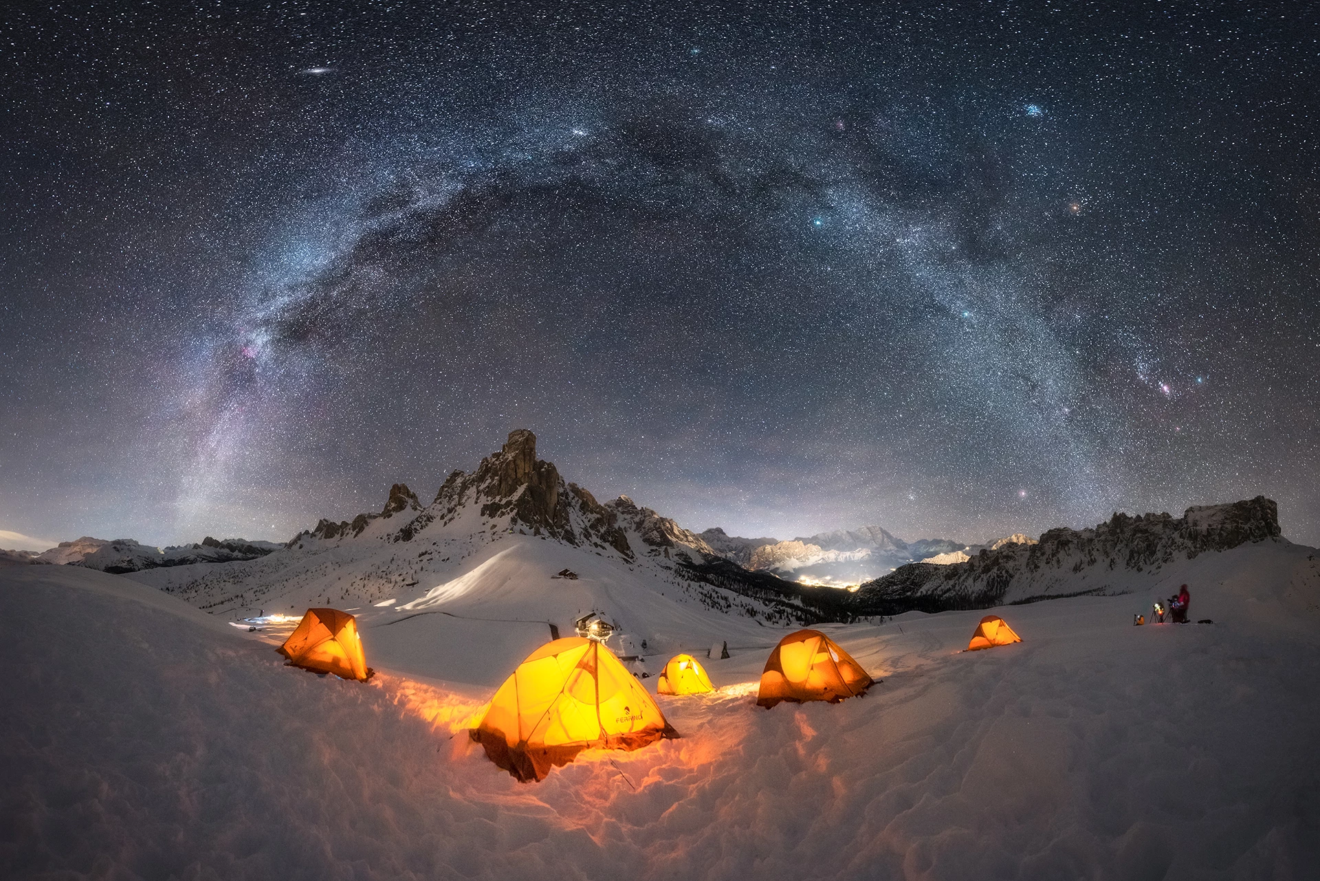 Base Camp, shot in the Dolomites, Italy. The warm glow of the tents contrasts the cool tones of the galaxy overhead.