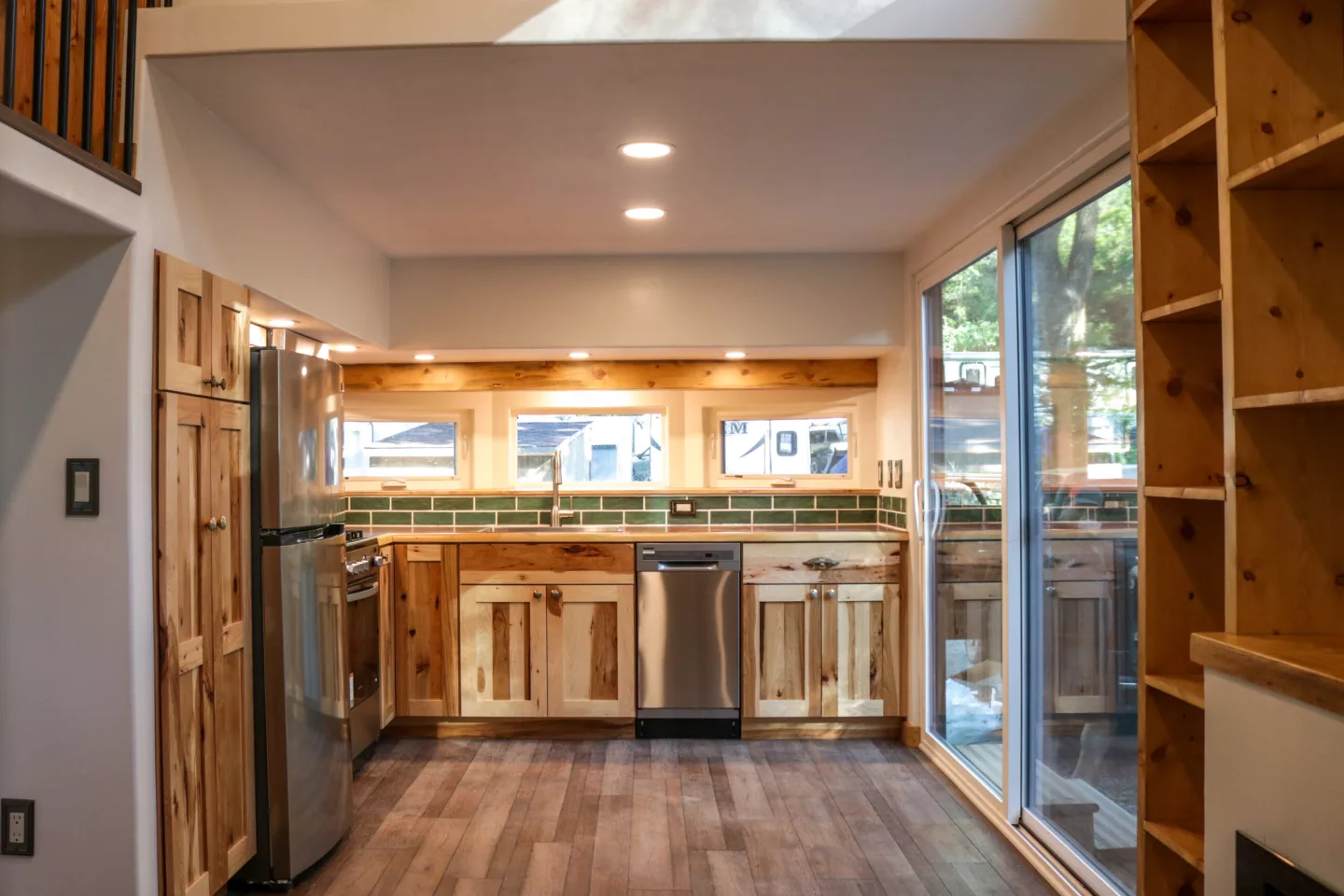 Visitors enter the Felicity 10' Wide tiny house's kitchen through double glass doors that help open up the home to the outside
