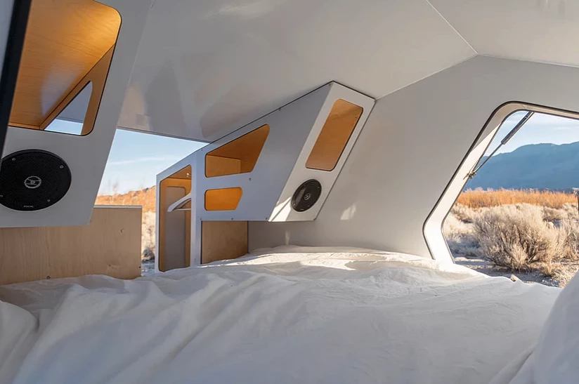 The passenger side has the available kitchenette behind its corner shelf, while the driver's side has a small wardrobe