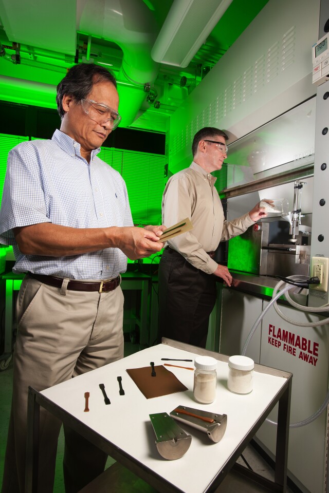 Plant physiologist Arland Hotchkiss (right) adds sugar beet pulp and polylactic acid to an extruder to make the bioplastic strips that chemist LinShu Liu is inspecting