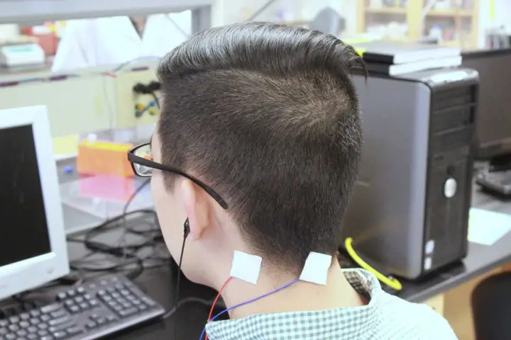 Chris Chang tests the tinnitus treatment device