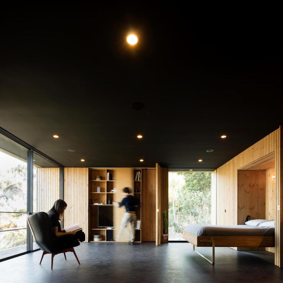The design of the 75-sq m dwelling maximizes the open interior space, by hiding many of the home's functions and storage within the walls
