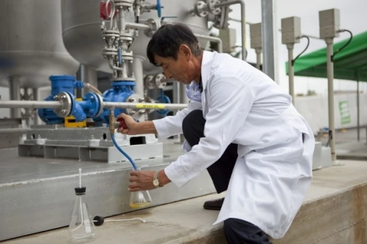 Tae Young Lee, Chief Engineer of Envion, collects oil from the Envion Oil Generator