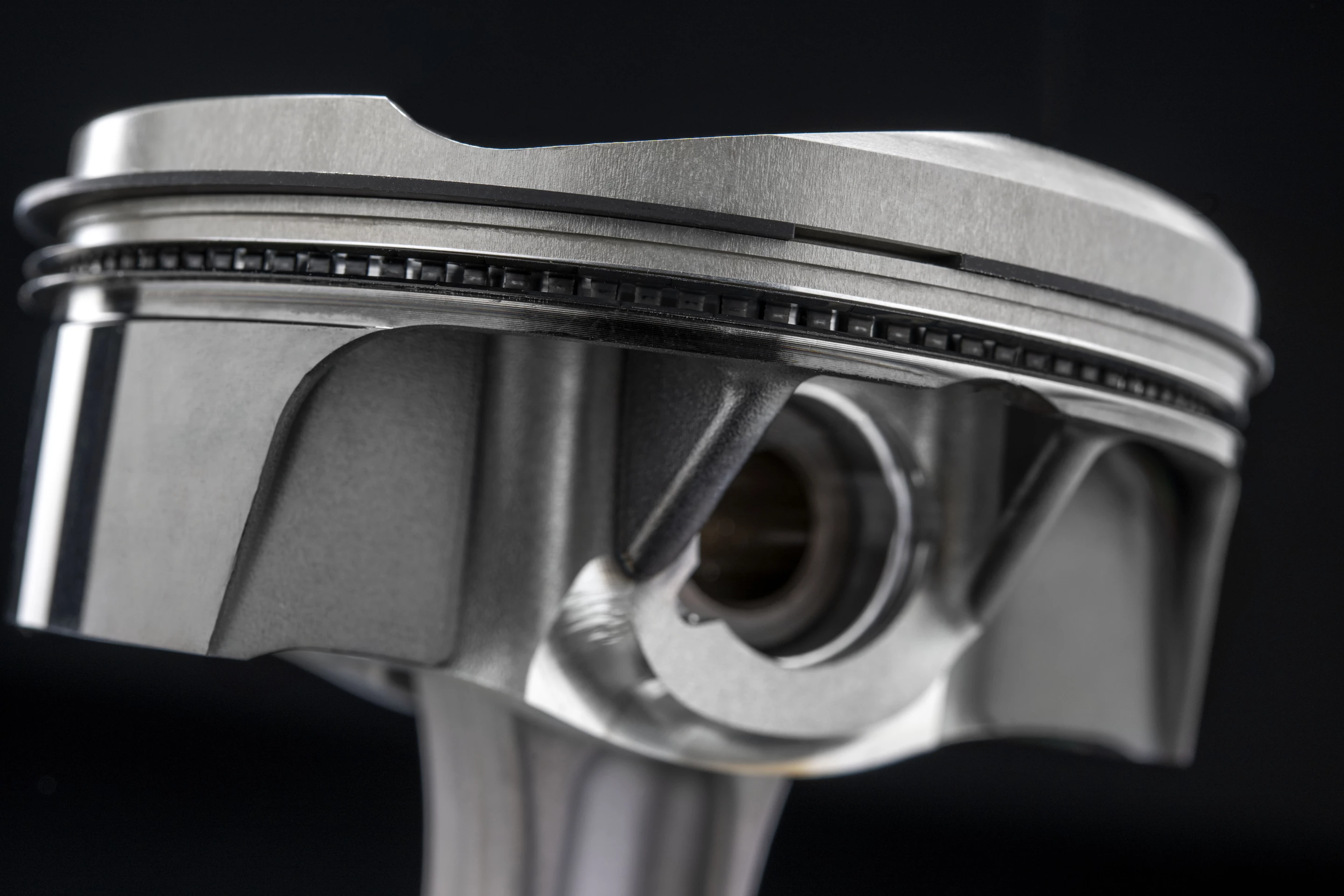 Diamond-like carbon surface treatments on the piston skirts further reduce