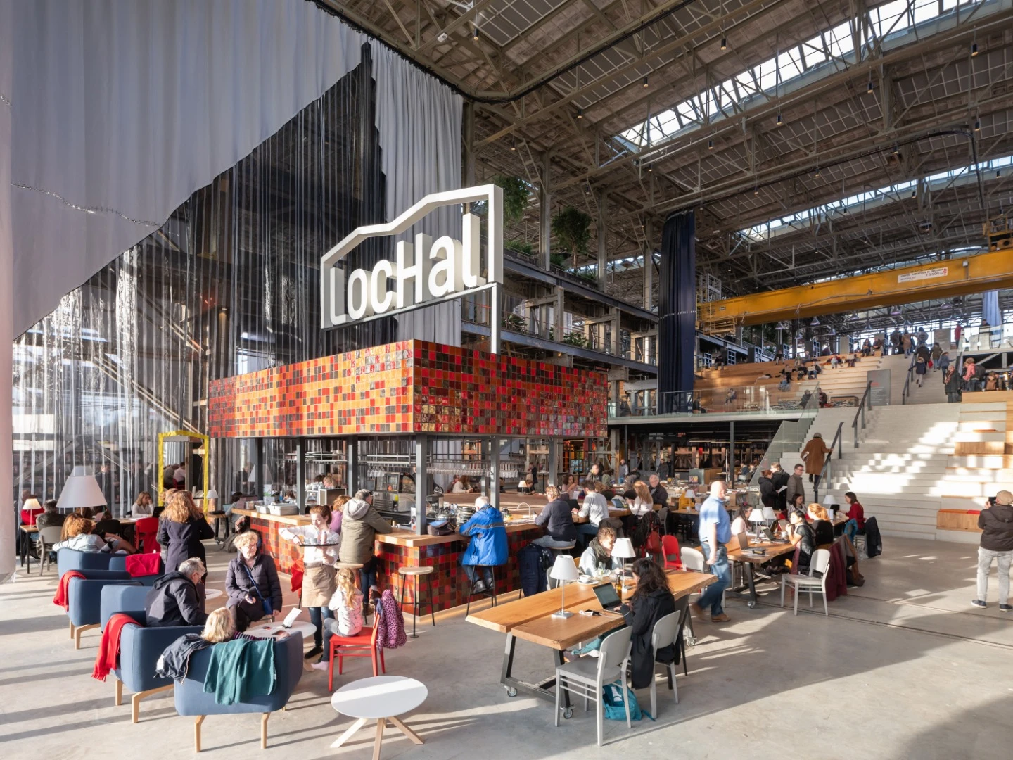 A central cafe decorated in eye-catching red, brown and gold ceramic tiles inside the LocHal Library