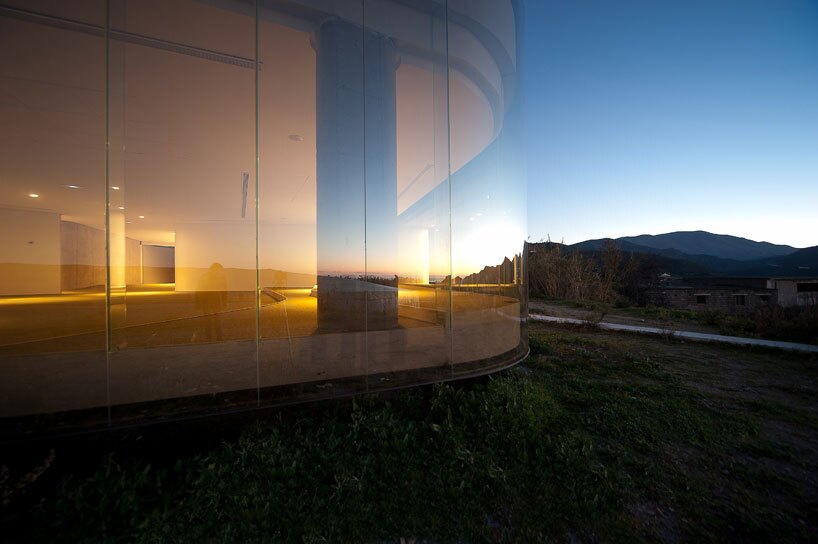 The main facade of the structure boasts impressive floor to ceiling glass panels, which reflect the surrounding landscape views