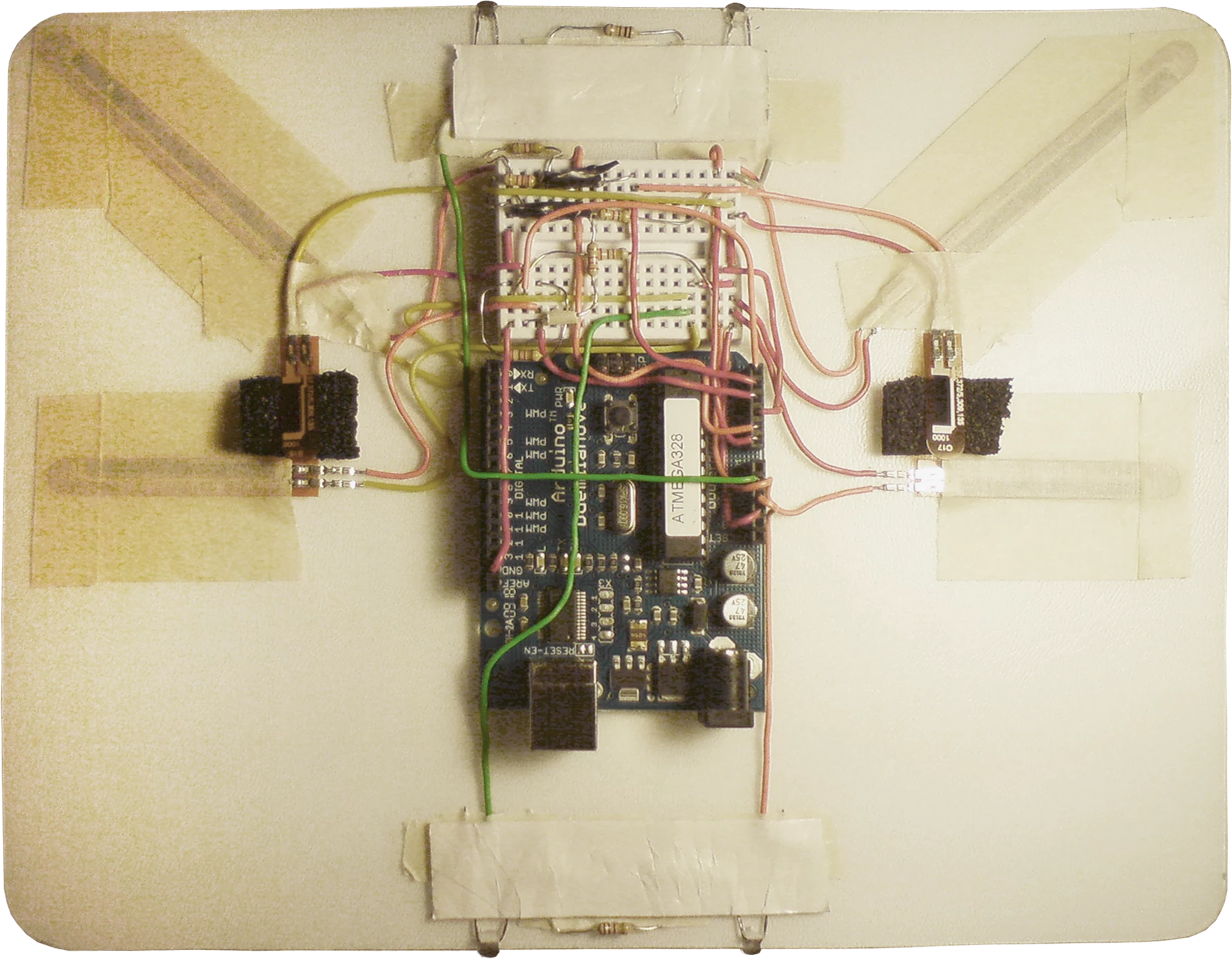 Between two thin plastic boards lies the circuitry, with infrared LEDs, pressure sensors and bidirectional bend sensors