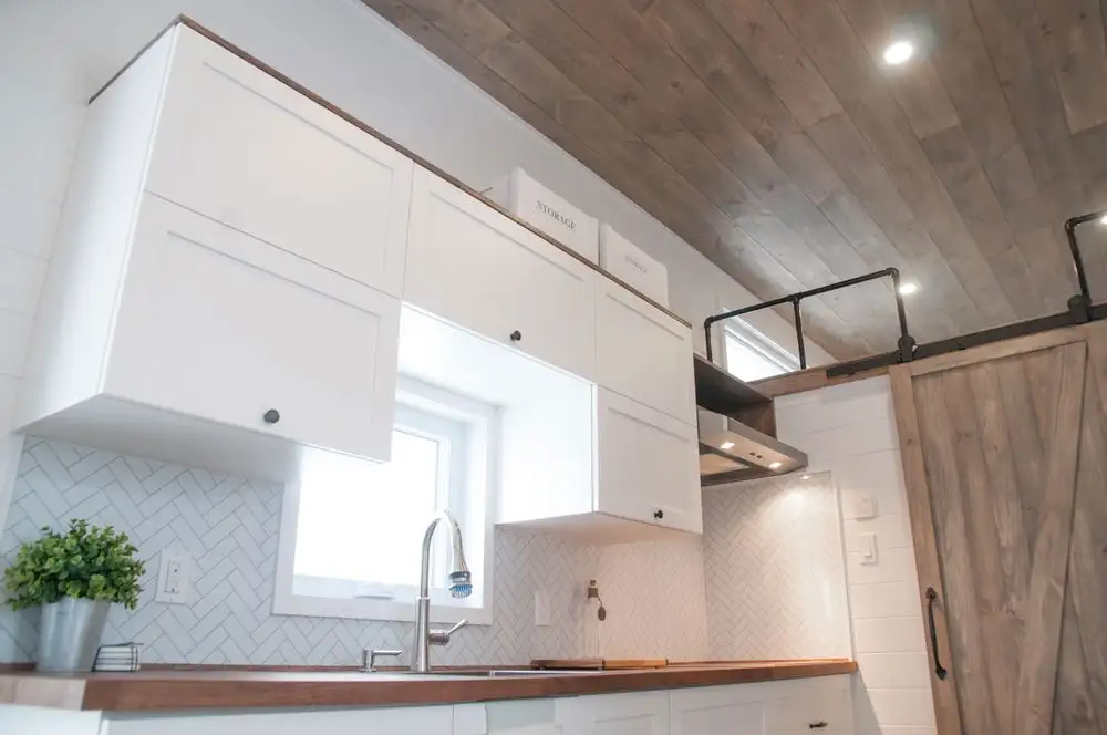 The Ébène's kitchen includes two freezers, a fridge, stainless steel sink, induction stove, and a microwave/oven