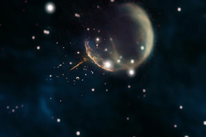 The CTB 1 supernova remnant, visible here as a "bubble." The speeding pulsar is a tiny dot at the end of the orange trail of magnetic energy to the lower left of the bubble