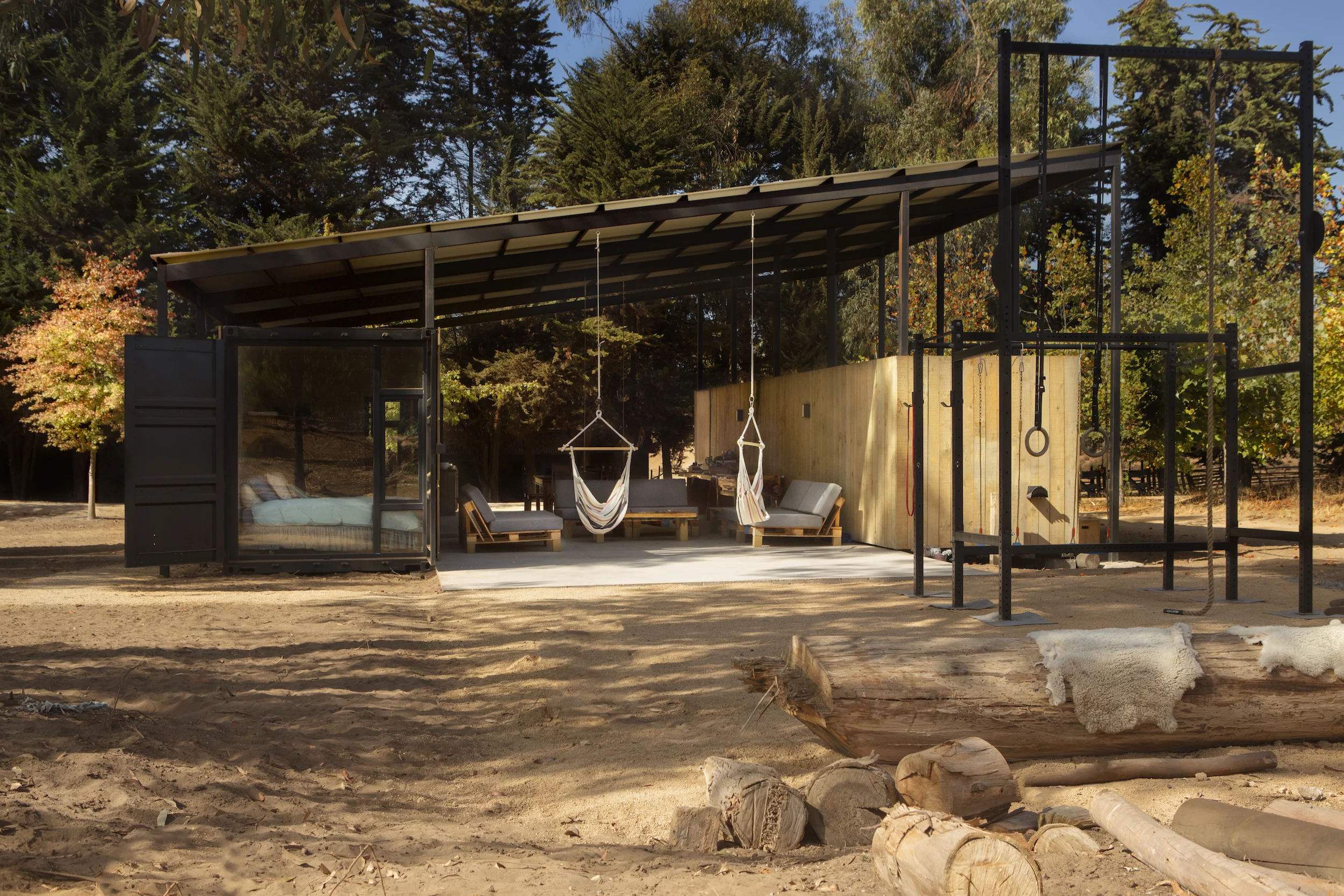 Container House includes two hammock chairs and some children's play equipment is nearby