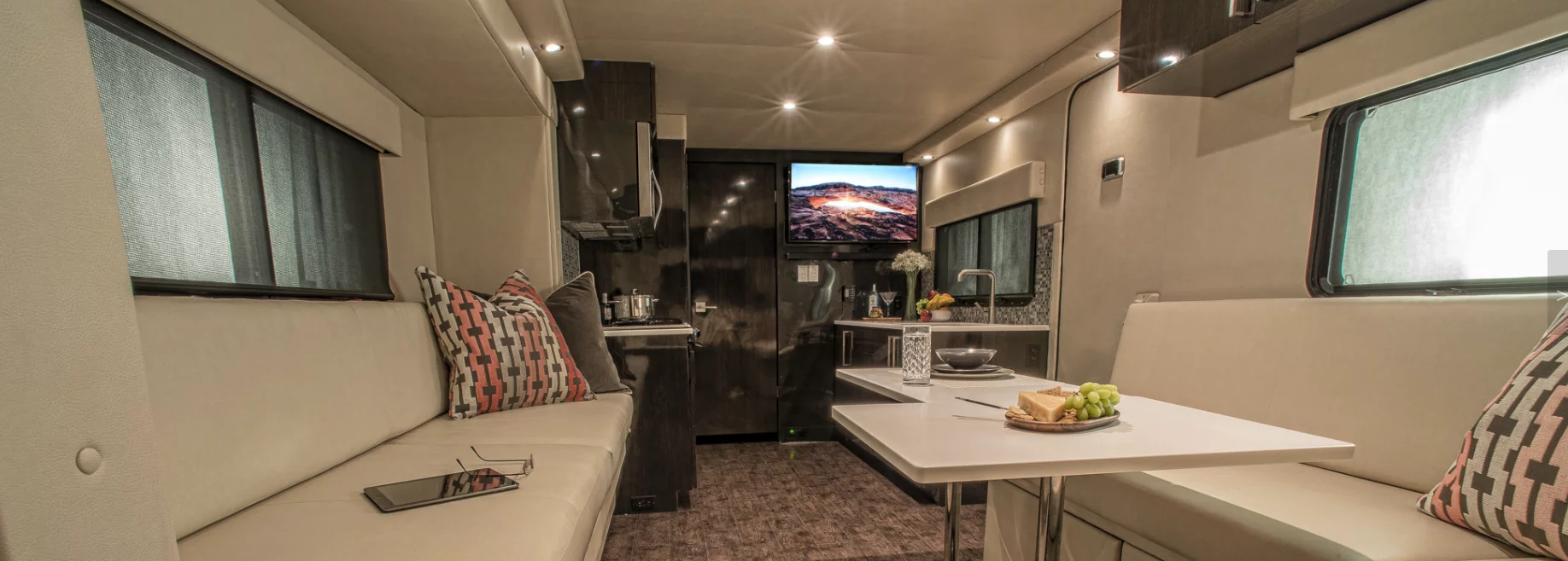 The interior includes modular tables, a kitchen and a rear entertainment lounge