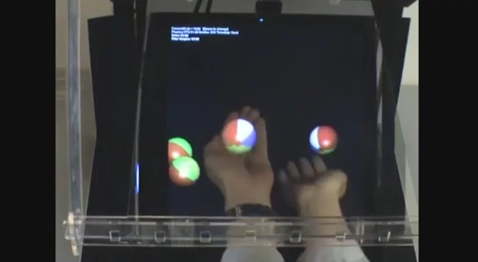The HoloDesk system uses Microsoft's Kinect camera, an overhead screen that projects a 2D image through a half-silvered beam splitter into a viewing area beneath, face-tracking software and custom algorithms to bring everything together in real time