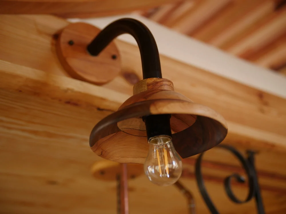The Honey on the Rock's interior has decorative touches like wooden lamps, and exposed soldered copper water piping