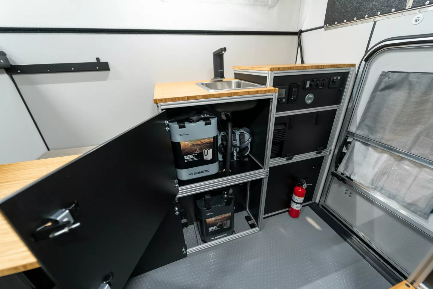 The water module houses three 11-L fresh water canisters and one 11-L waste water canister hooked up to a sink with Dometic GO faucet