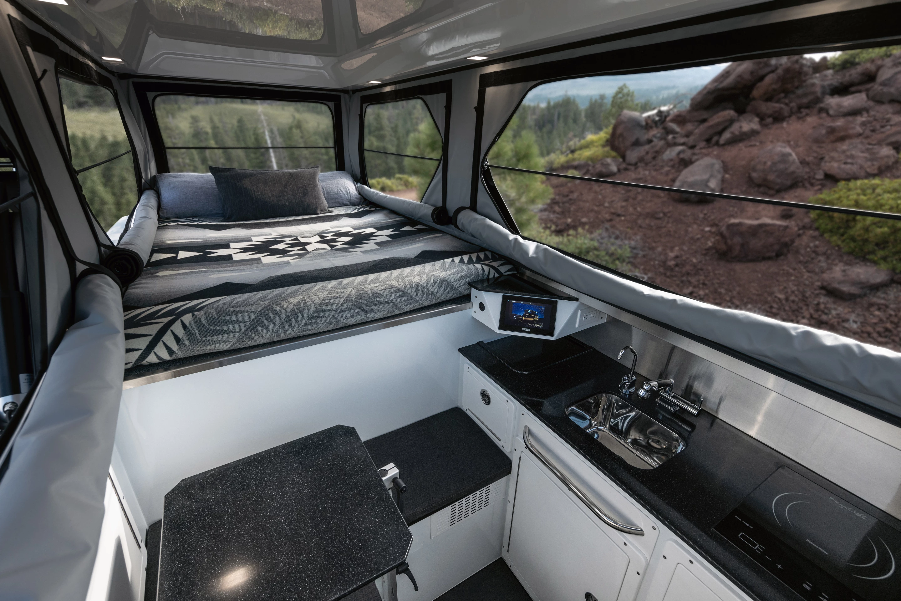 EarthCruiser makes the most out of the Hummer EV Pickup's 5-foot bed, installing a full kitchen and small L-shaped dinette below and behind the sleeper alcove
