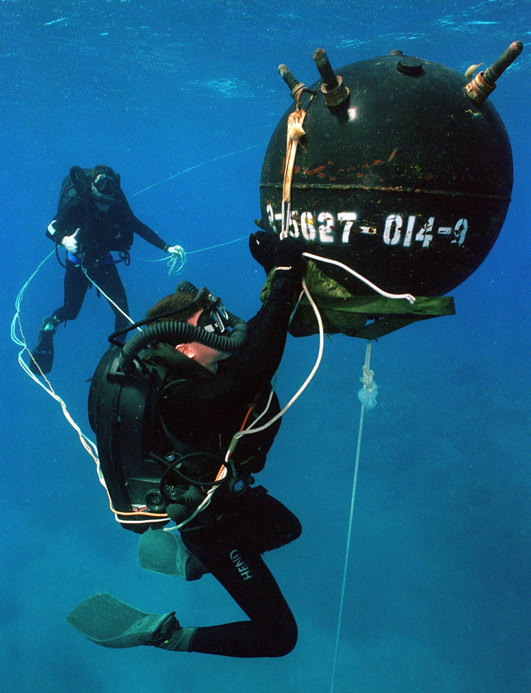 US Navy divers with a practice mine