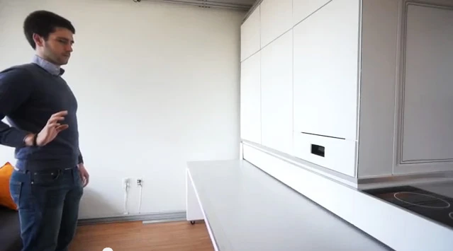 The CityHome wall unit stows a bed, dining room table, kitchen and range, plus a closet, and a work station