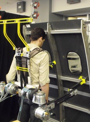 Robotic limbs assist the operator to stabilize his balance against a structure – the yellow structure above the operator's head contains sensors