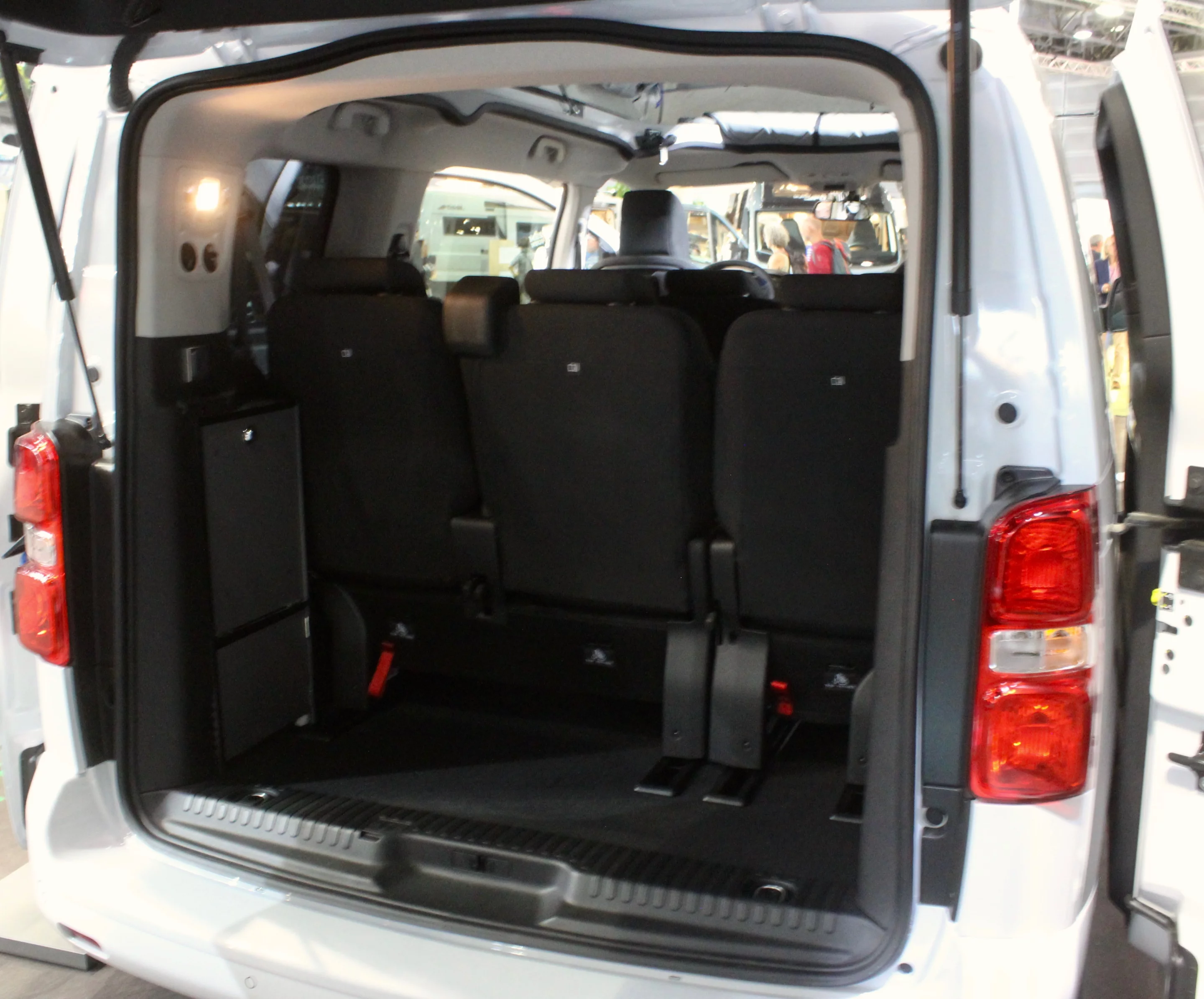 The unassuming console on the left side holds a fold-out shelf with induction cooker, part of the standard e-Vanster package