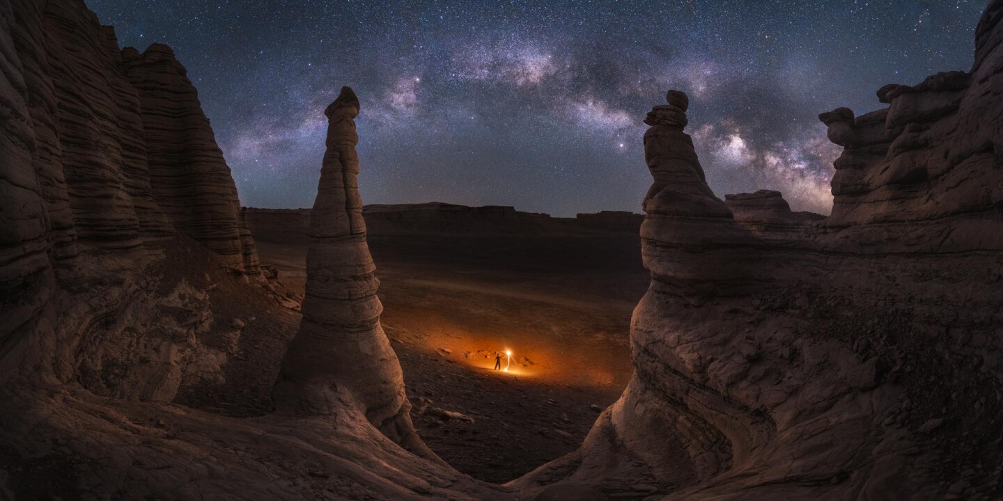 Lightning The Milky Way. A lighted figure stands among the wind-eroded rock formations of Dahaido Desert, Xinjiang, China
