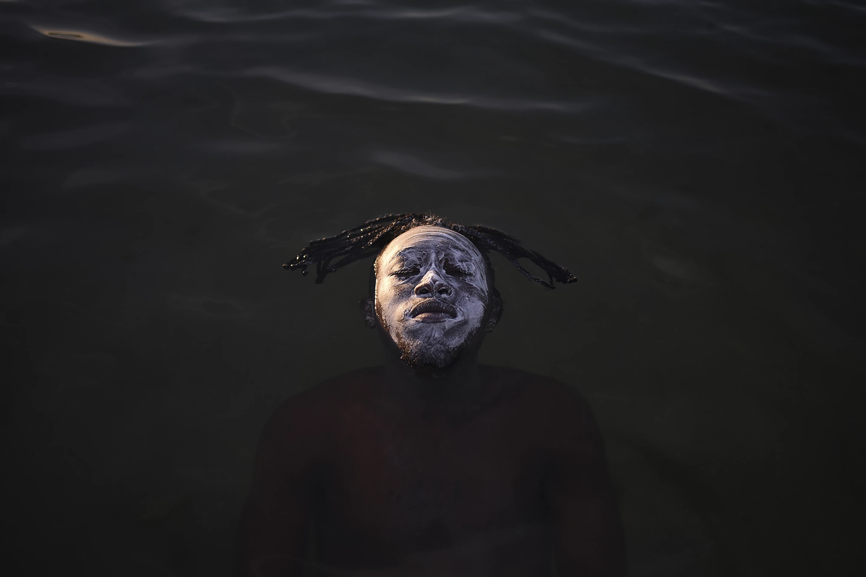 Second Place, People and Nature. A young African refugee from the Democratic Republic of Congo floating in the waters of Guanabara Bay, Ramos Beach.