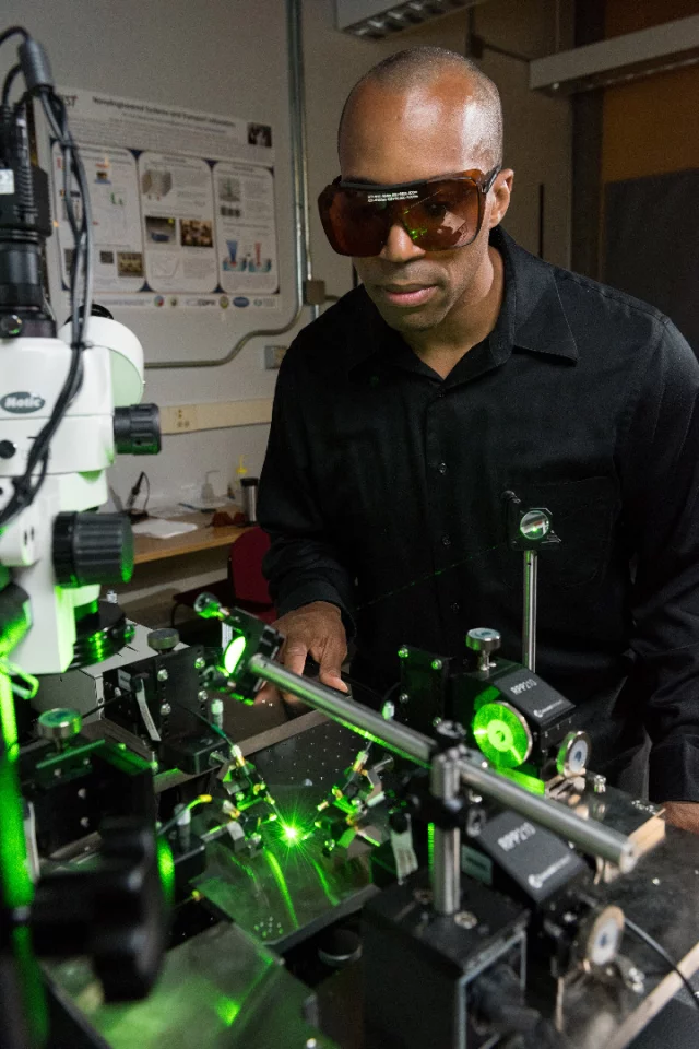 Associate professor Baratunde Cola observing a laser being used in his research on visible-light rectennas
