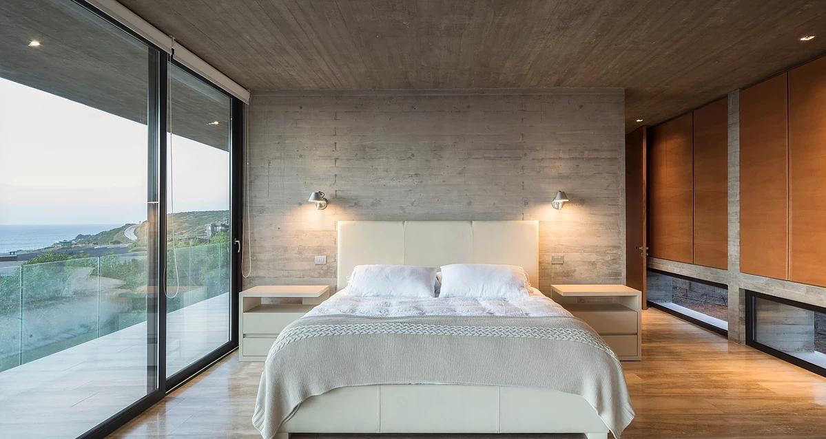 La Casa H is built into hills around the coastal town of Zapallar, leaning on a set of four monster reinforced concrete beams running the length of the structure