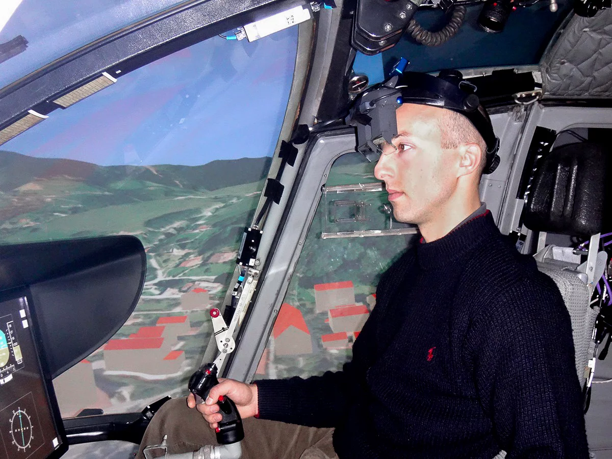 A pilot wearing the augmented reality system inside a helicopter flight simulator