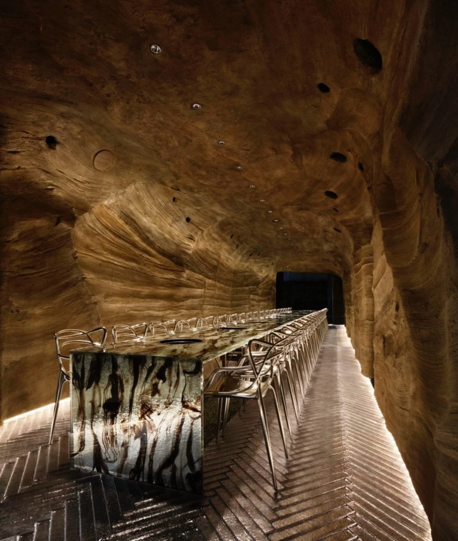 A nominee for Best Craftsmanship and Best Use of Material, this Japanese restaurant called Nikunotoriko consists of two floors: one resembles a cave with a bespoke long glass table, and the other floor is designed to be a hillside environment with laser-cut contoured floors