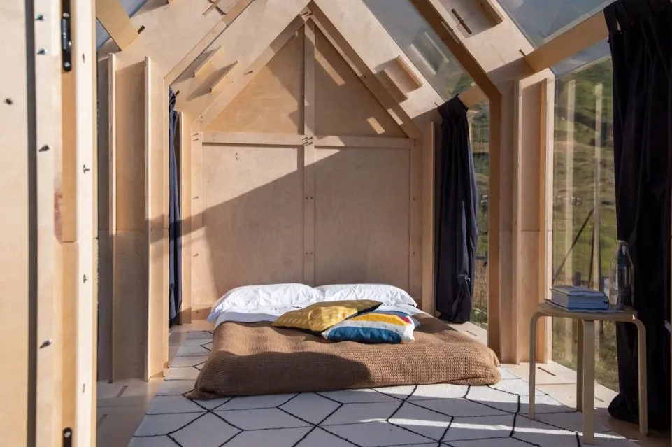 The interior of the cabin features a double bed, coffee table and enough storage space for luggage
