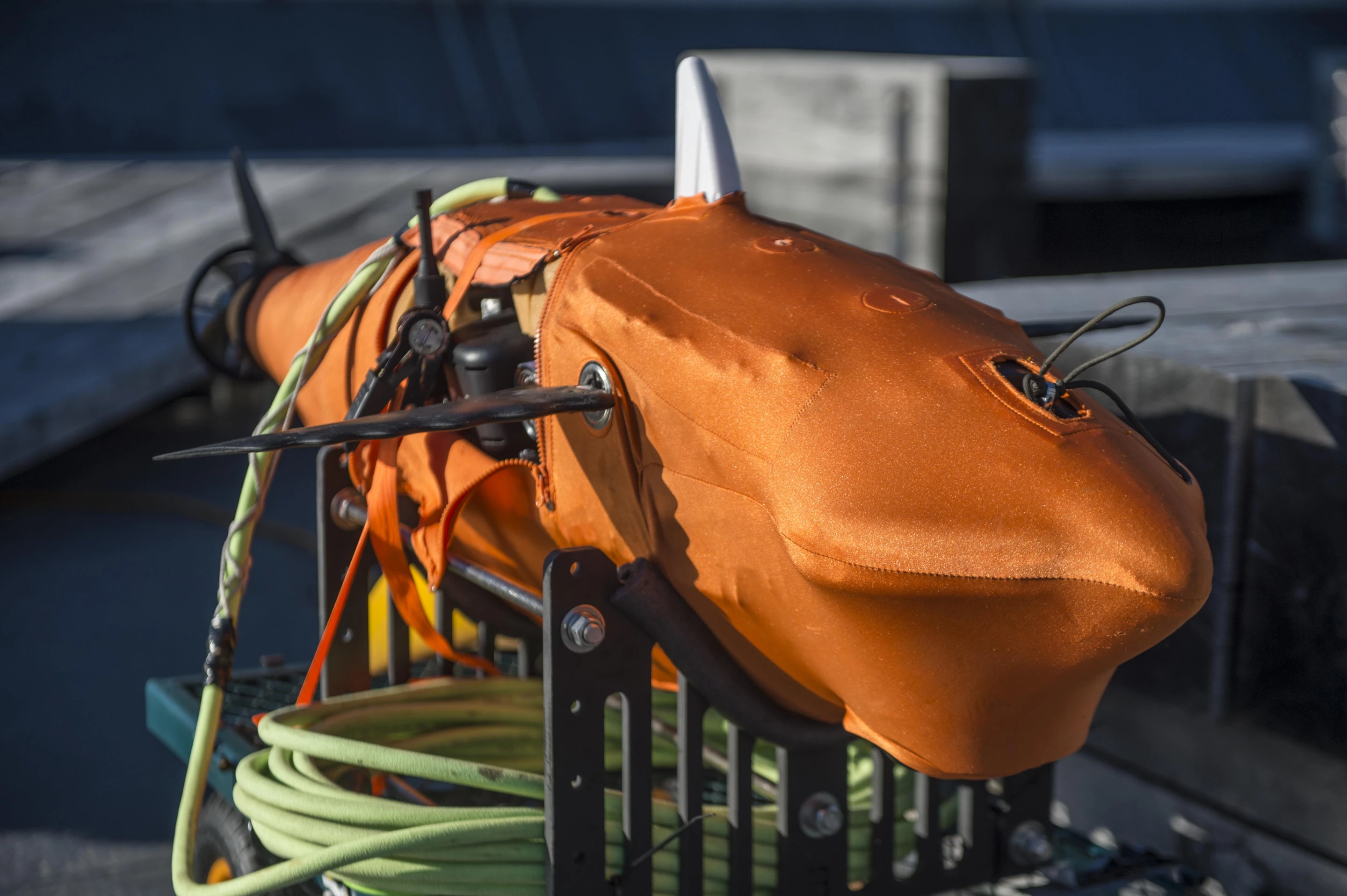 The device is about five feet (1.5 m) long, weighs almost 100 lb (45 kg), and is described as mimicking the body shape and swinging-tail-driven swimming style of "a large fish"