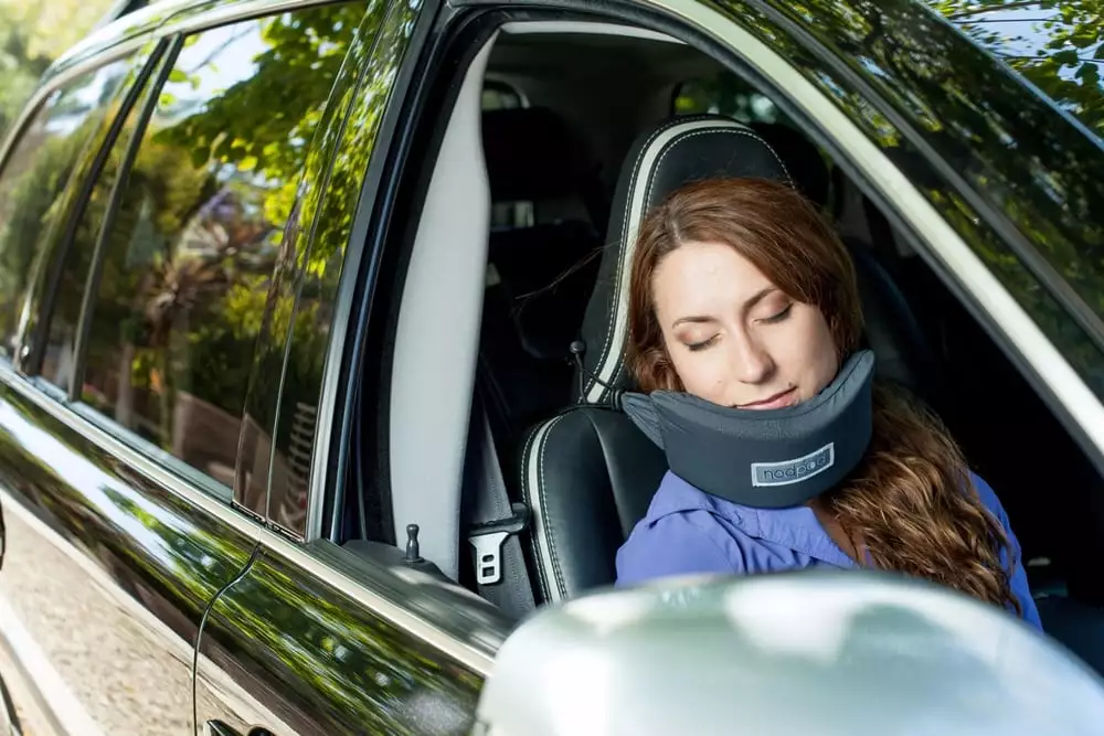 The NodPod's cords slip over the rear of a seat or headrest to secure a support for your chin