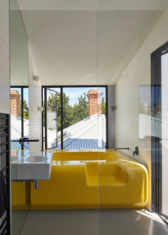 Austin Maynard Architects made its own bath (in bright yellow) using fiberglass that sports no seams