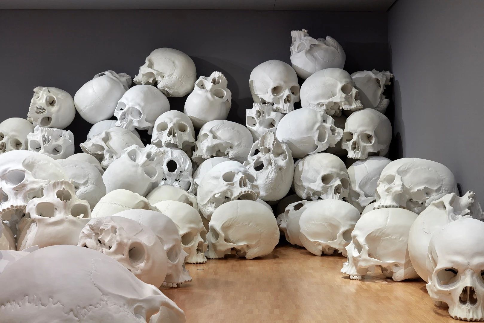 Ron Mueck's huge installation features 100 giant skulls strewn around the gallery's classic art collection
