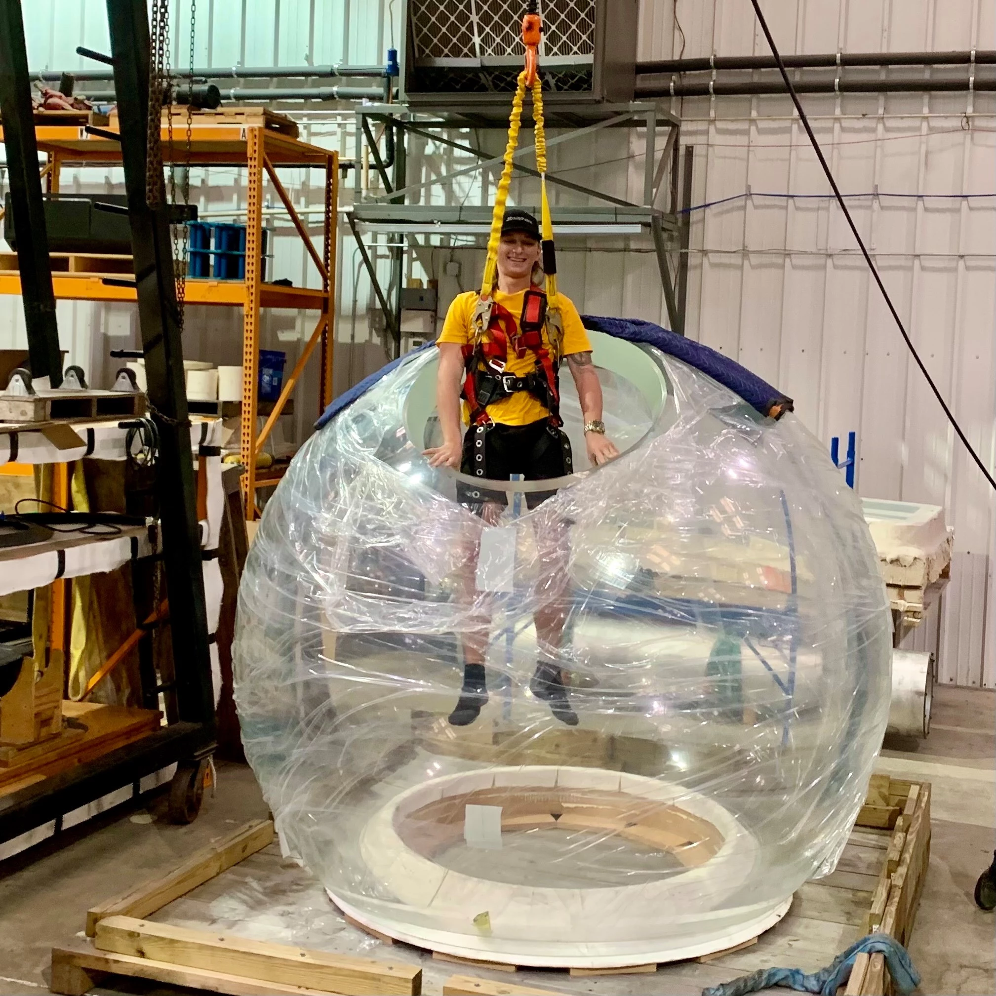 One of the sub building team being lowered into a freshly-delivered acrylic hull