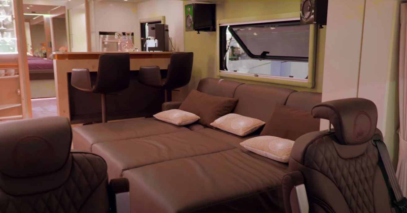 The custom floor plan includes a front daybed and a two-person bar