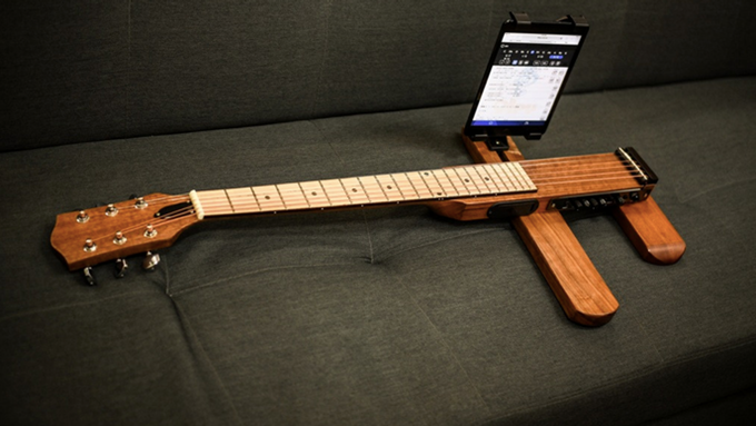 The Cross Guitar 2.0 comes with a smartphone mount to make learning from videos easier